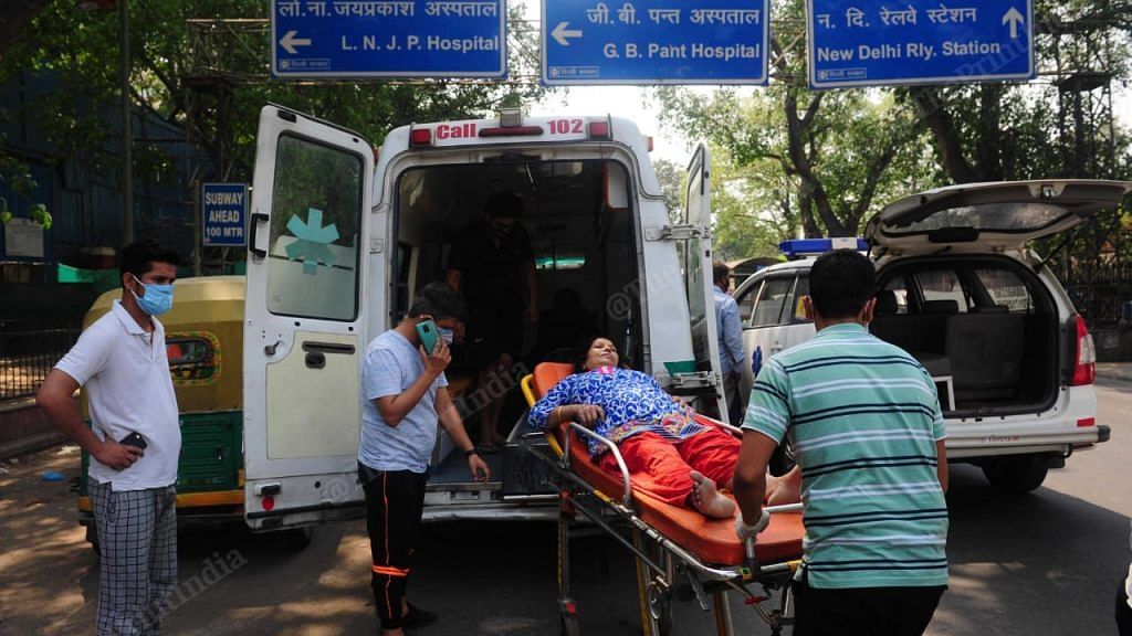 A covid patient being shifted from one ambulance to another after the oxygen in the cylinder got over, outside LNJP Hospital in New Delhi | Suraj Singh Bisht | ThePrint