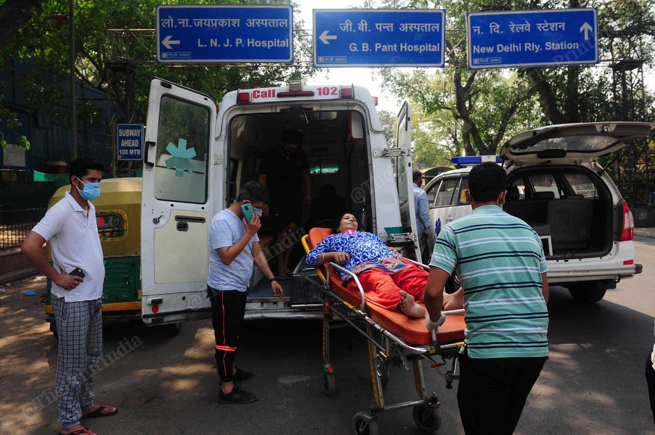 A covid patient was being shifted from one ambulance to another as the oxygen in the cylinder finishes in the ambulance outside LNJP | Suraj Singh Bisht | ThePrint