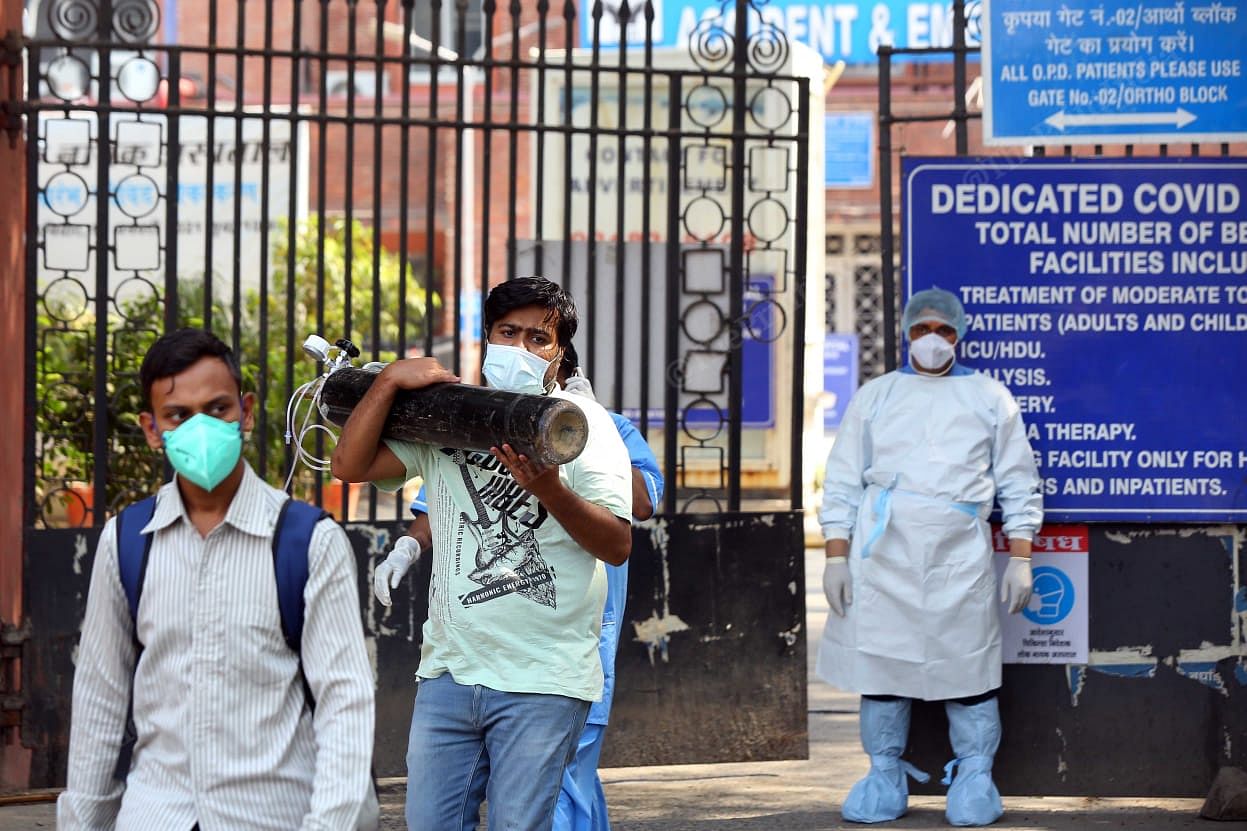 Outside LNJP hospital, family members waiting for help. This man carried a oxygen cylinder for his pregnant wife who was sitting in the car inside | Suraj Singh Bisht | ThePrint