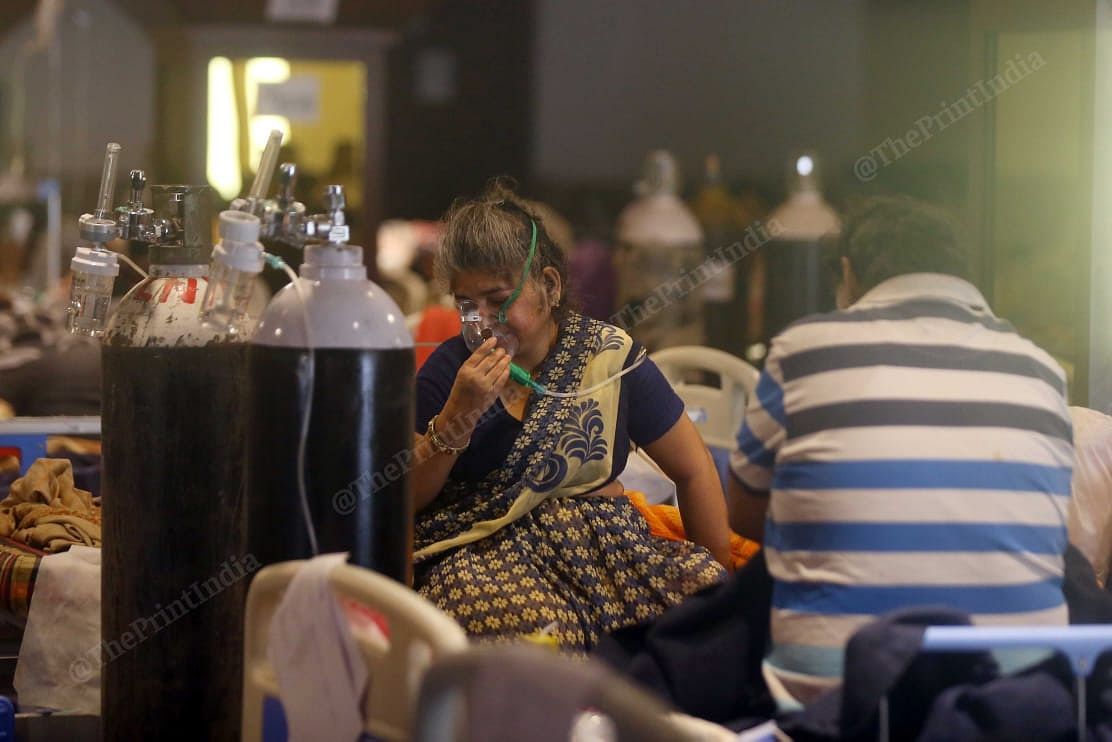 At Shehnai banquet an old woman uses oxygen cylinder to breathe. The family members of patients were quite happy with the facility, they said the doctors are taking good care | Suraj Singh Bisht | ThePrint