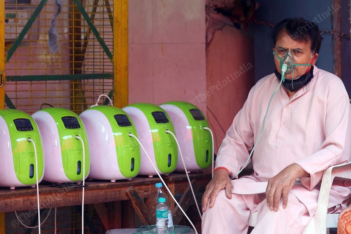 At the Indirapuran Gurdwara, a man uses concentrator to breathe. The gurudwara has provided oxygen cylinders as well for the patients | Suraj Singh Bisht | ThePrint