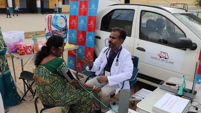 Dr Sunil Kumar Hebbi with a patient next to his 'mobile clinic' in pre-Covid times | Photo: Facebook | Sunil Kumar Hebbi