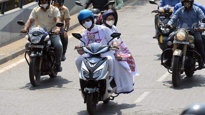 West Bengal CM Mamata Banerjee is driven from her residence to Nabanna by state minister Firhad Hakim on an electric scooter as a mark of protest against rising fuel prices, in February 2021 | ANI