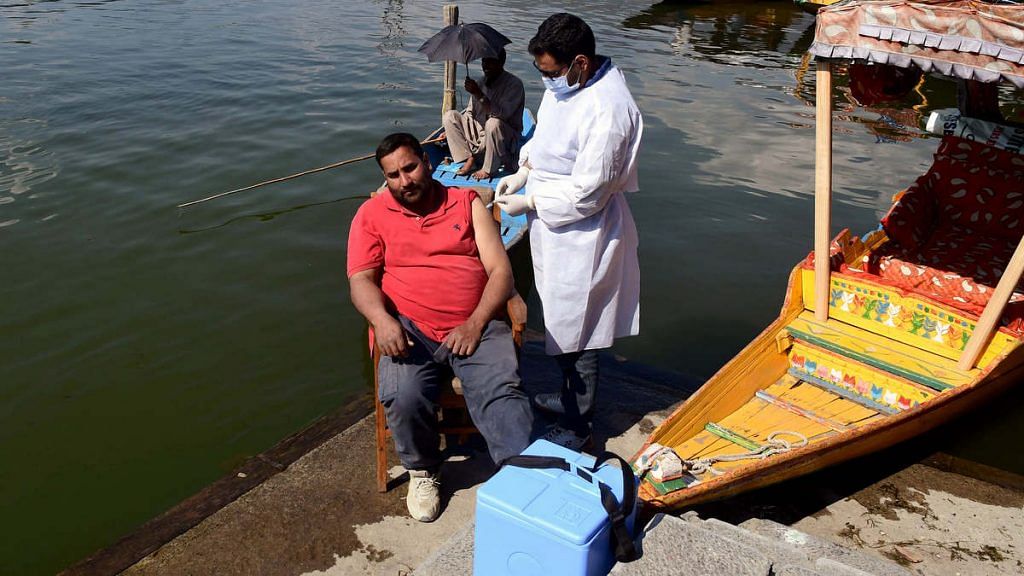 A medic administers the Covid-19 vaccine beside a shikara at the Dal Lake in Srinagar | Photo: ANI