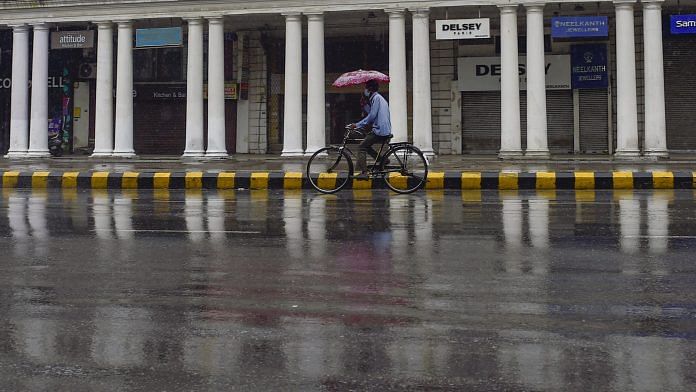 A cyclist with an umbrella during a mild shower in New Delhi | Representational Image| PTI