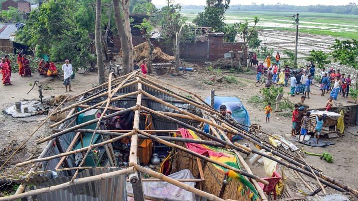 Villagers are seen standing next to a roof of the house which was damaged during cyclone 'Yaas', at Santipur in West Bengal, on 27 May 2021 | PTI