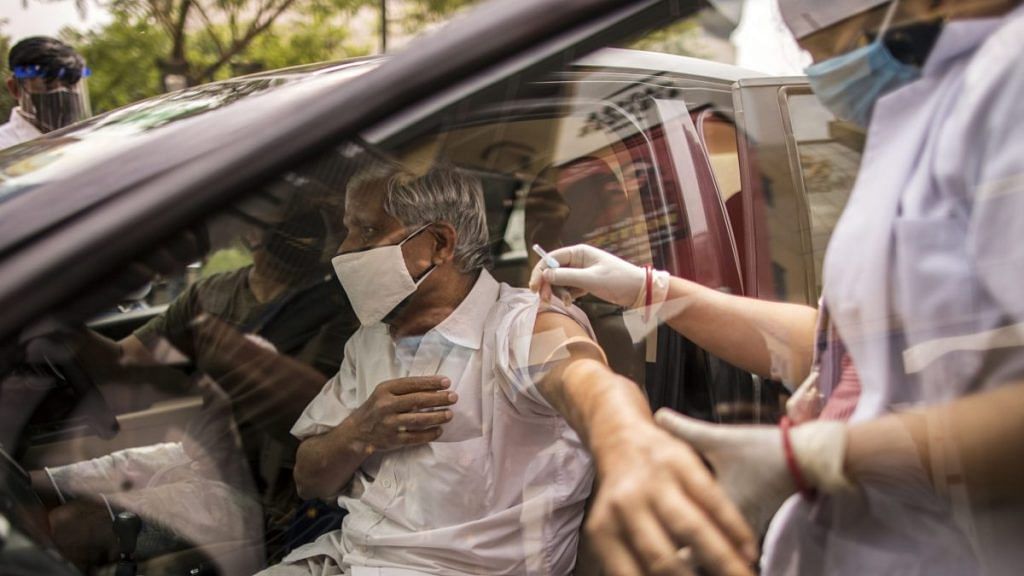A person receives a dose of Covid-19 vaccine at a drive-thru vaccination site set up at the DLF Mall of India in Noida, UP | Photographer: Anindito Mukherjee | Bloomberg