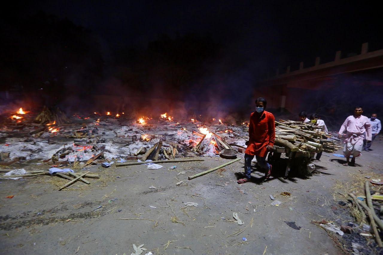 Workers at the Seemapuri crematorium carry woods on a cart | Praveen Jain | ThePrint