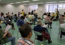 People wait to receive a dose of the Moderna vaccine at a newly-opened mass vaccination site in Tokyo, on 24 May 2021