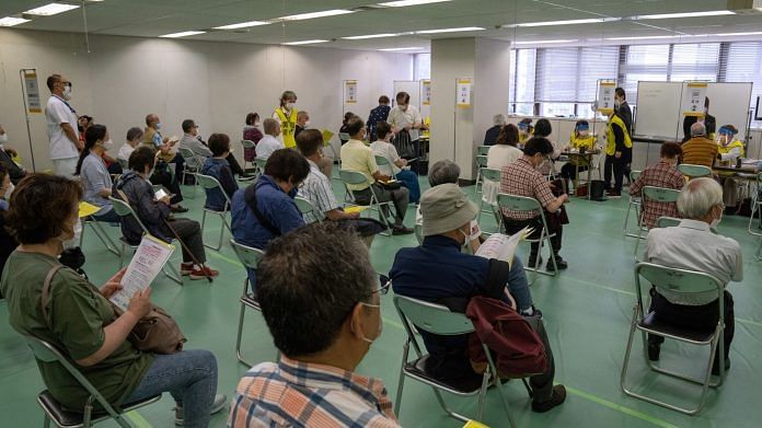 People wait to receive a dose of the Moderna vaccine at a newly-opened mass vaccination site in Tokyo, on 24 May 2021