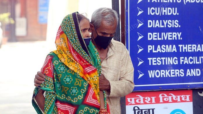 An old man holds his ailing wife outside LNJP | Praveen Jain | ThePrint