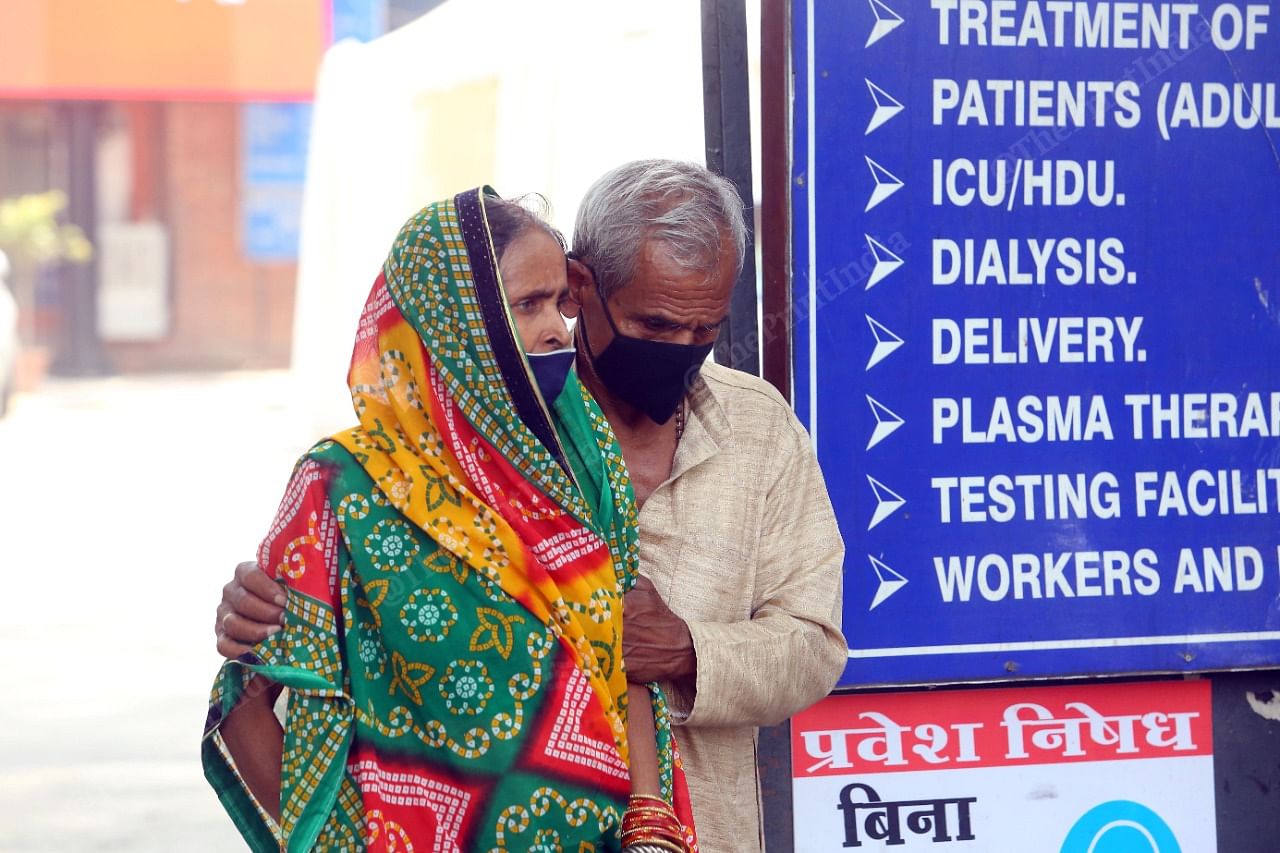 An old man holds his ailing wife outside LNJP | Praveen Jain | ThePrint