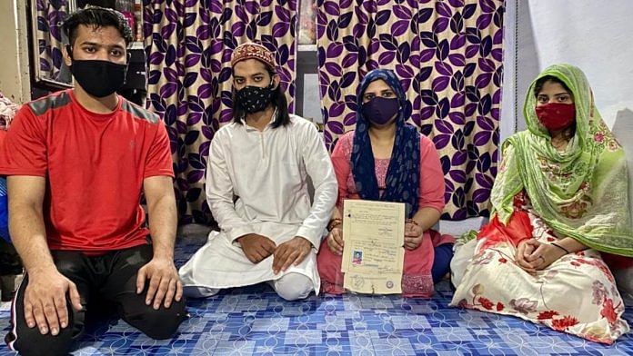 Nusrat Jahan sits with the 'gas peedit' card of her husband Anwar Ahmed, a gas tragedy survivor who died of Covid on 5 May. The couple's children are also seen in the image | Nirmal Poddar | ThePrint
