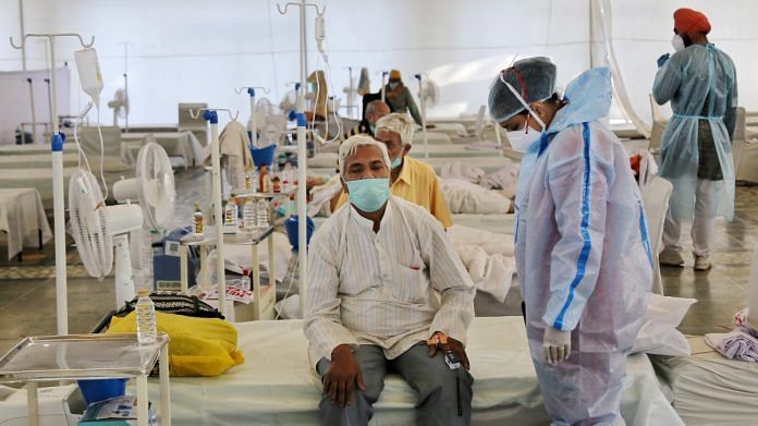 A health worker in PPE kit stand near Covid-19 patient, at Covid Care Center Rakabganj Gurudwara in New Delhi, on 25 May 2021 | PTI