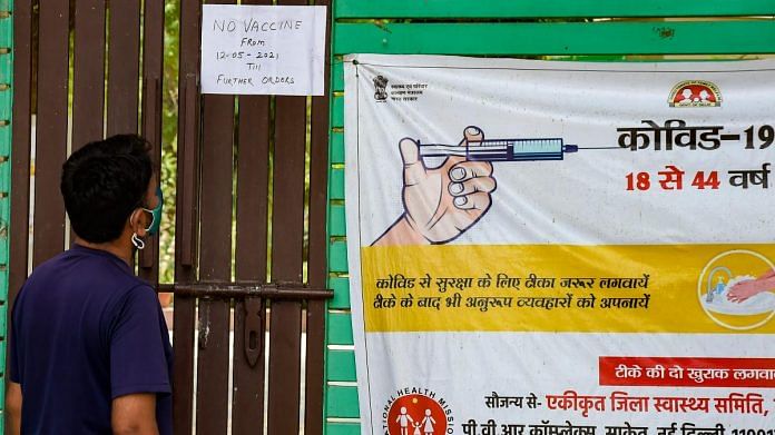A man looks at a notice stating non-availability of vaccines, outside a vaccination centre in New Delhi, on 12 May 2021 | PTI