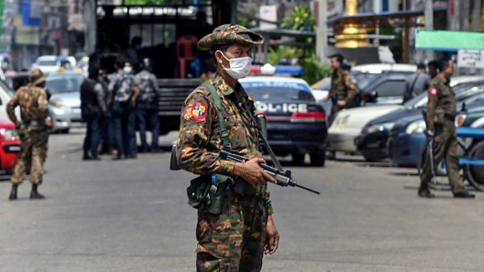 A soldier stands guard along a road as security forces search for protesters, who had been taking part in a demonstration against the military coup, in Yangon, on 7 May 2021 | Photographer: STR/AFP/Getty Images via Bloomberg