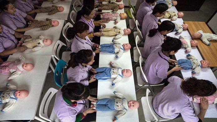 Chinese women training to be qualified nannies, known in China as ayis, learn techniques with plastic babies in Beijing | Photo by Kevin Frayer/Getty Images via Bloomberg