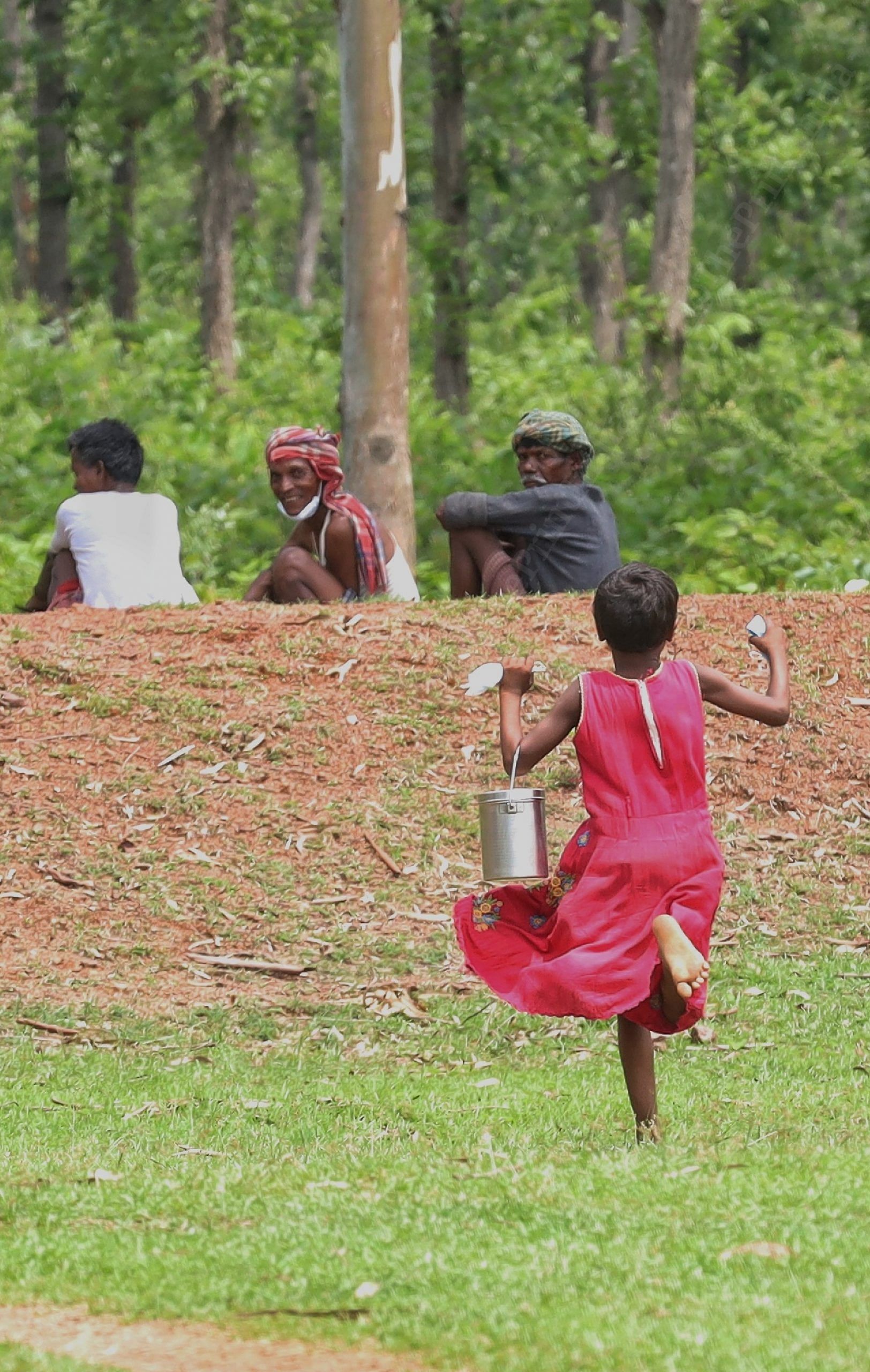 A girl run across the field carrying lunchbox | Photo: Manisha Mondal | ThePrint