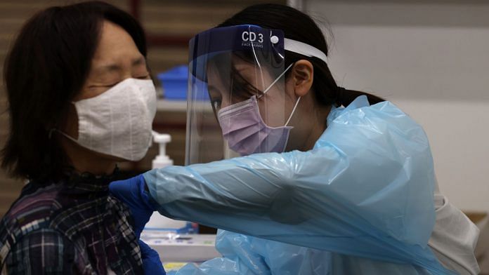A healthcare worker administers a dose of the Pfizer-BioNTech Covid-19 vaccine at a mass inoculation site at Noevir Stadium Kobe in Japan | Photographer: Buddhika Weerasinghe | Bloomberg