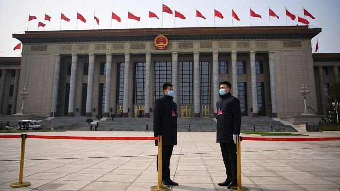 Security staff stand guard outside the Great Hall of the People in Beijing | Photographer: Noel Celis/AFP/Getty Images via Bloomberg