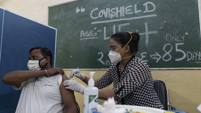 A health workers administers a dose of the Covishield vaccine at a vaccination center set up at Navyug School in New Delhi | Photographer: Sumit Dayal | Bloomberg