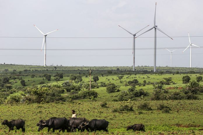 Wind turbines operating beyond electricity cables in Lahori, Madhya Pradesh, India |Photographer: Dhiraj Singh/Bloomberg
