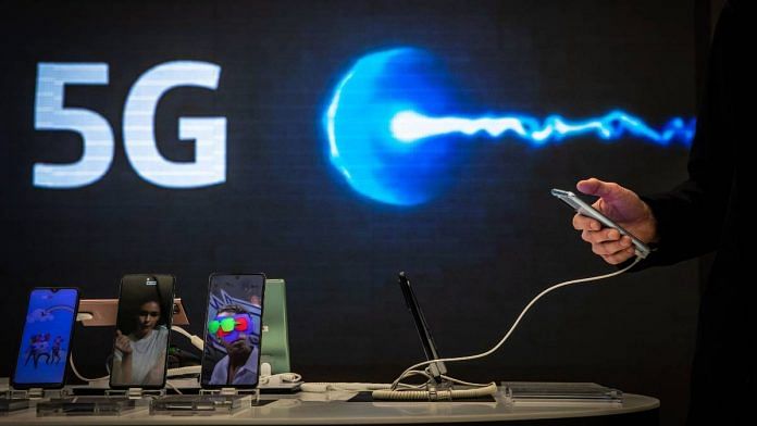 A customer browses a smartphone device in front of a 5G logo inside the Movistar center, in Barcelona, Spain, in January 2021 | Angel Garcia | Bloomberg