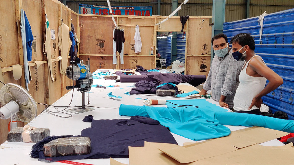 Mrityunjay Sharma, 29, who owns a clothing unit, with a designer who works with him | Sajid Ali | ThePrint