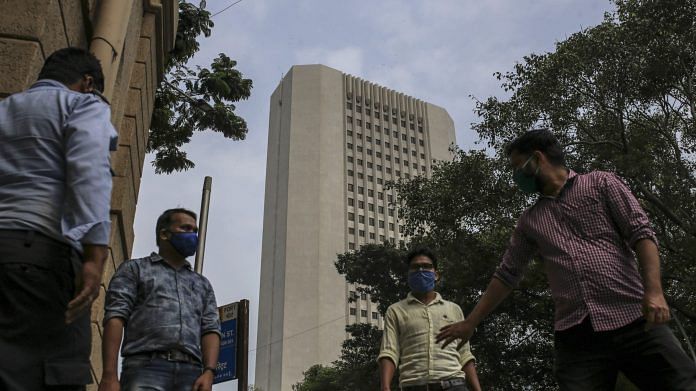 Pedestrians wearing protective masks walk near RBI headquarter building in Mumbai | Photo: Dhiraj Singh | Bloomberg File Photo