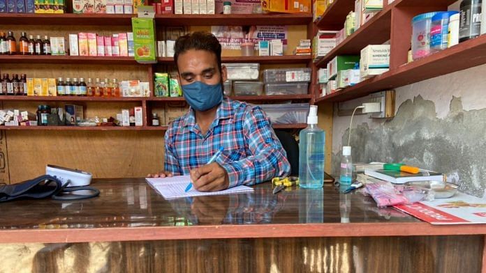 Jagdesh, a registered medical practitioner at Patiala's Bolar Kalan village. notes down details of patients who visit him with Covid-like symptoms | Reeti Agarwal | ThePrint