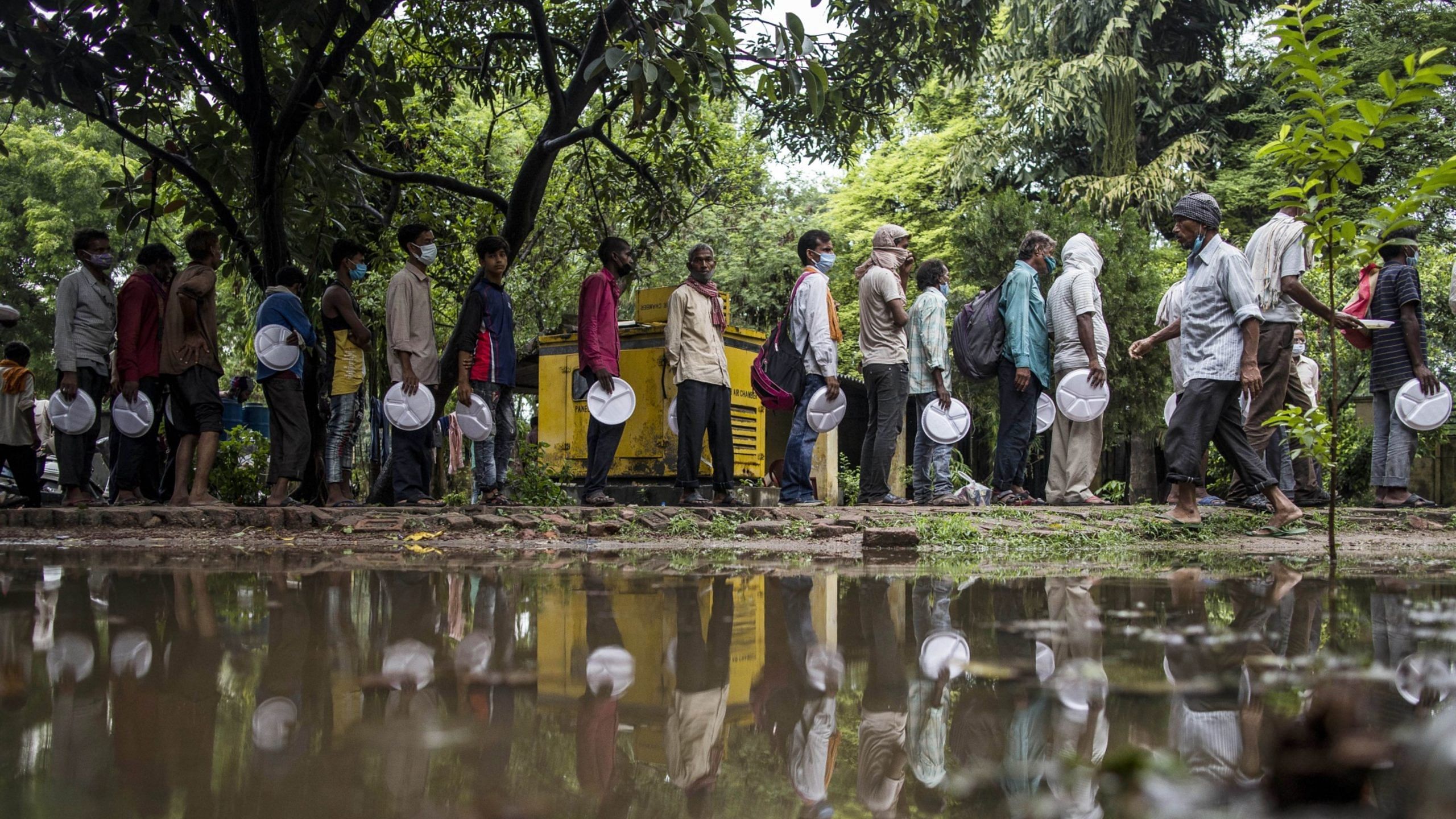 Free Vaccines, Food to Cost India an Additional $11 Billion People line up to receive free meals distributed by volunteers in Lucknow on 10 June