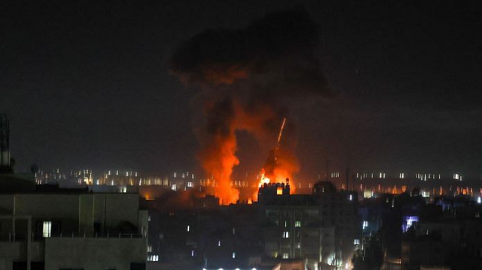 Explosions light-up the night sky above buildings in Gaza City as Israeli forces shell the Palestinian enclave, on 16 June 2021 | Photo: Mahmud Hams | AFP/Getty Images via Bloomberg