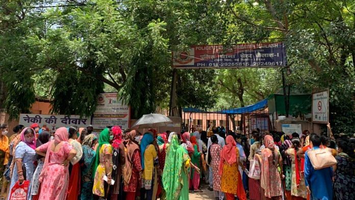Women queue up for free ration being distributed by an NGO in GK 1 | Aneesha Bedi | ThePrint