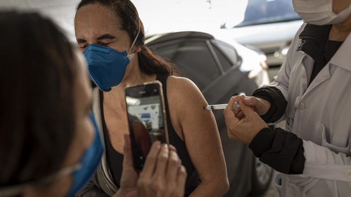 A health worker administers a vaccine dose at the Latin America Memorial in Sao Paulo, Brazil | Bloomberg