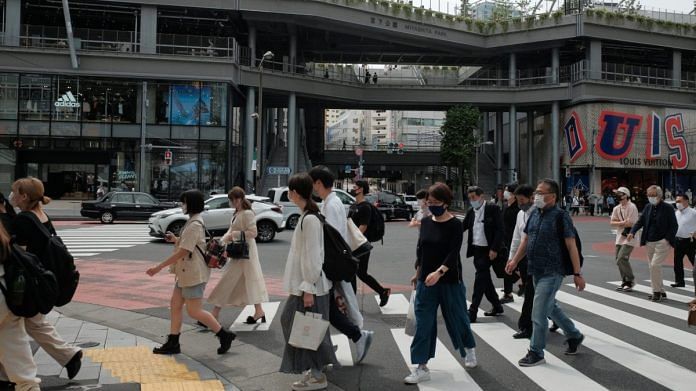 Pedestrians wearing protective face masks cross an intersection passing Miyashita Park in the Shibuya district of Tokyo, on 2 June 2021 | Photographer: Soichiro Koriyama | Bloomberg