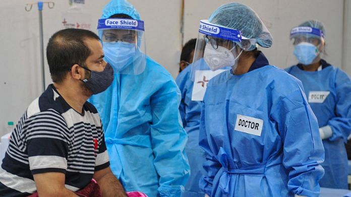 Health workers wearing PPE kits attend to Covid-19 patients at a newly set up temporary hospital at Tau Devi Lal Stadium in Gurugram, on 27 May 2021 | PTI