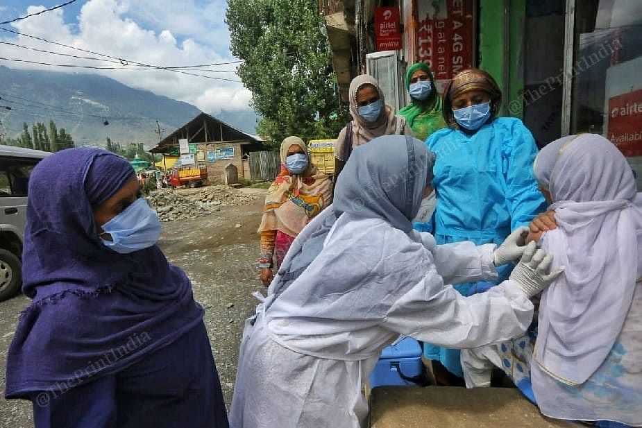 Health worker doing vaccinating local lady at the road at the Sonerwani village in Bandipora Distt in Kashmir | Photo: Praveen Jain | ThePrint