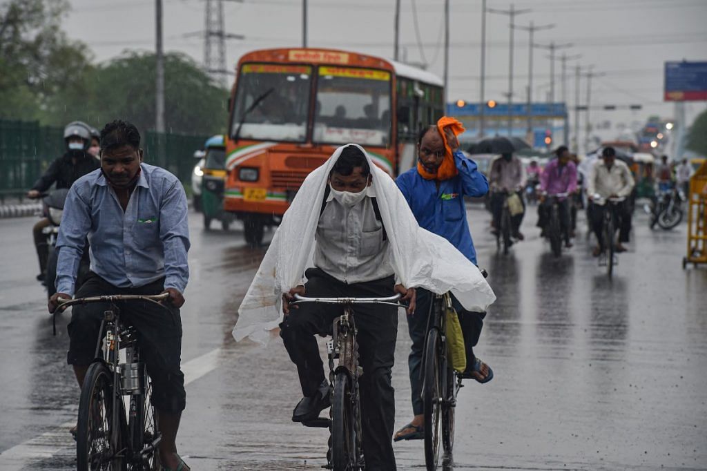 Commuters during rain as monsoon reaches Delhi on 13 July 2021 | PTI
