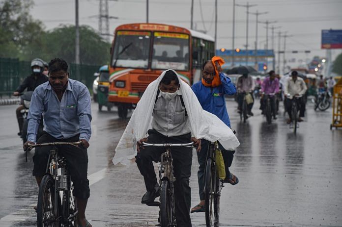 Commuters during rain as monsoon reaches Delhi on 13 July 2021 | PTI