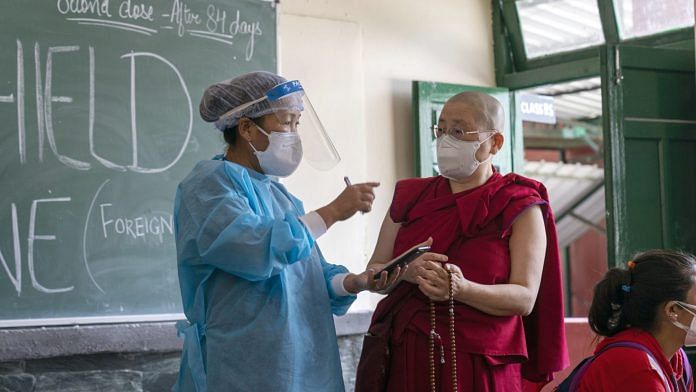 A health worker speaks with a Buddhist monk at a vaccination center set up at a Tibetan Children's Village School in Dharamshala, Himachal Pradesh | Photographer: Sumit Dayal | Bloomberg