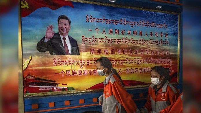 Tibetan students pass a poster showing Chinese President Xi Jinping in Lhasa, on 1 June 2021 | Photographer: Kevin Frayer/Getty Images AsiaPac via Bloomberg