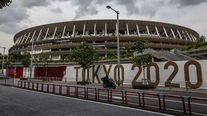 A man drives past the New National Stadium, the main stadium for the Tokyo Olympics, on 3 June 2021 in Tokyo | Photographer: Yuichi Yamazaki/Getty Images via Bloomberg