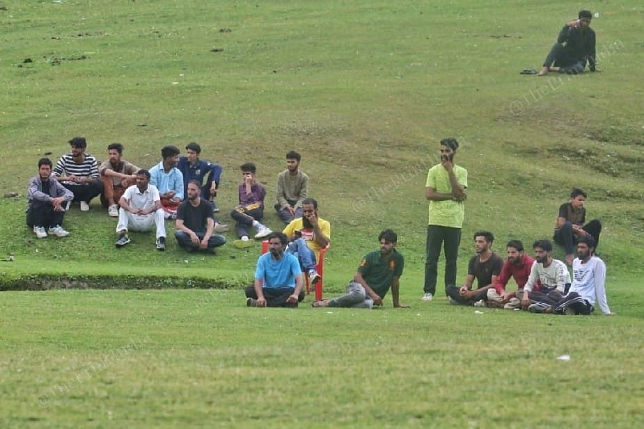 Spectators enjoying the match sitting on the grass at the ground of Homepabthri District Kulgam | Photo: Praveen Jain | ThePrint