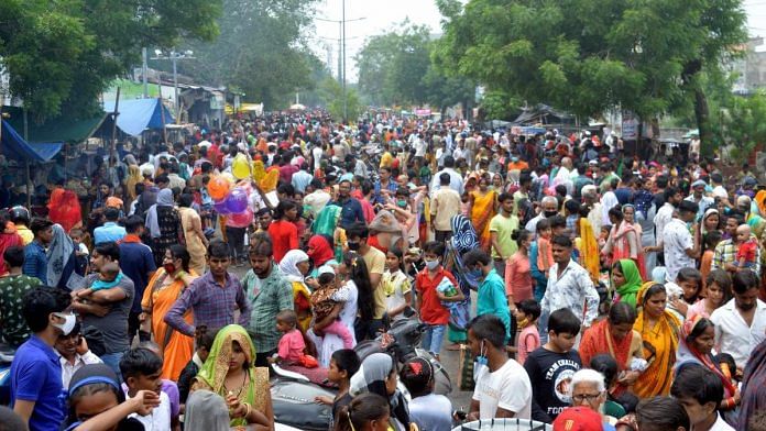 People flout social distancing norms as they visit a crowded annual fair after authorities eased Covid-induced lockdown in Agra, on 12 July 2021 | PTI