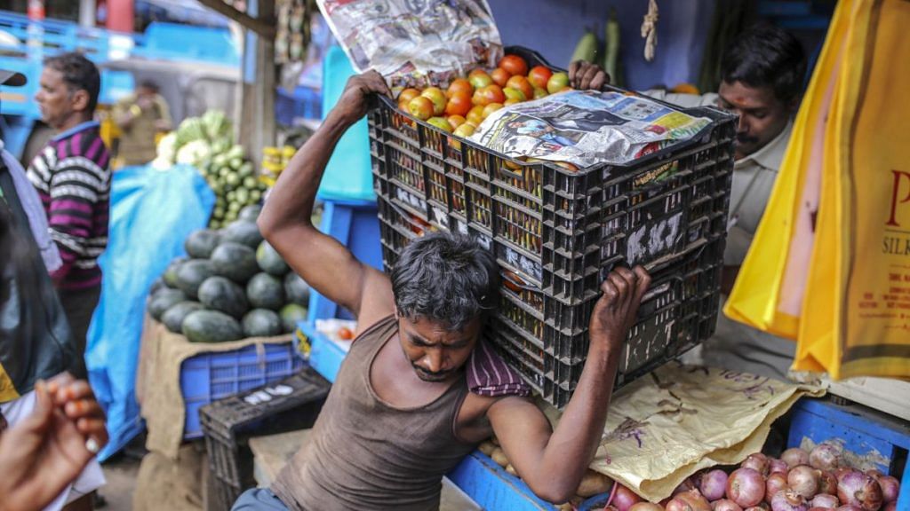 A worker unloads crates of tomatoes from a truck at a vegetable store in Coonoor, Tamil Nadu | Representational image | Dhiraj Singh | Bloomberg File Photo