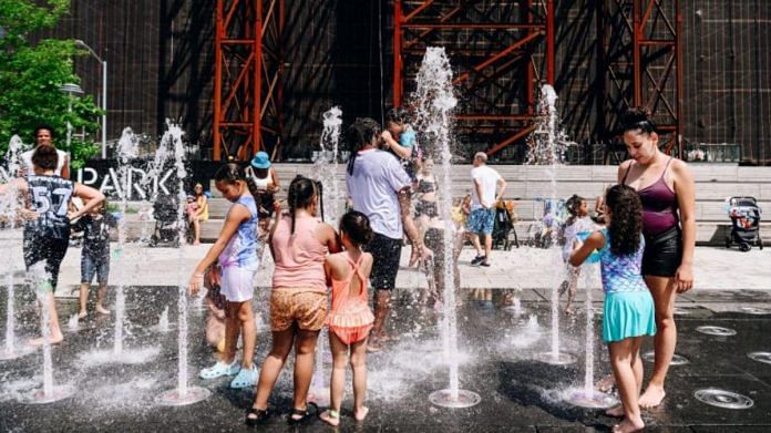 Visitors cool off in the splash pad at Domino Park during a heatwave in the Brooklyn borough of New York, on 29 June 2021 | Nina Westervelt | Bloomberg