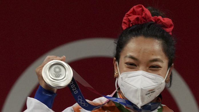 India's Mirabai Chanu poses for photographs on the podium after winning the silver medal at the Summer Olympics 2020, in Tokyo on 24 July 2021 | PTI Photo/Gurinder Osan