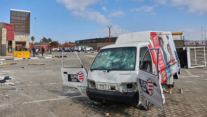 A badly damaged vehicle outside a supermarket following rioting in the Soweto district of Johannesburg, on 15 July 2021 | Photo: Waldo Swiegers | Bloomberg