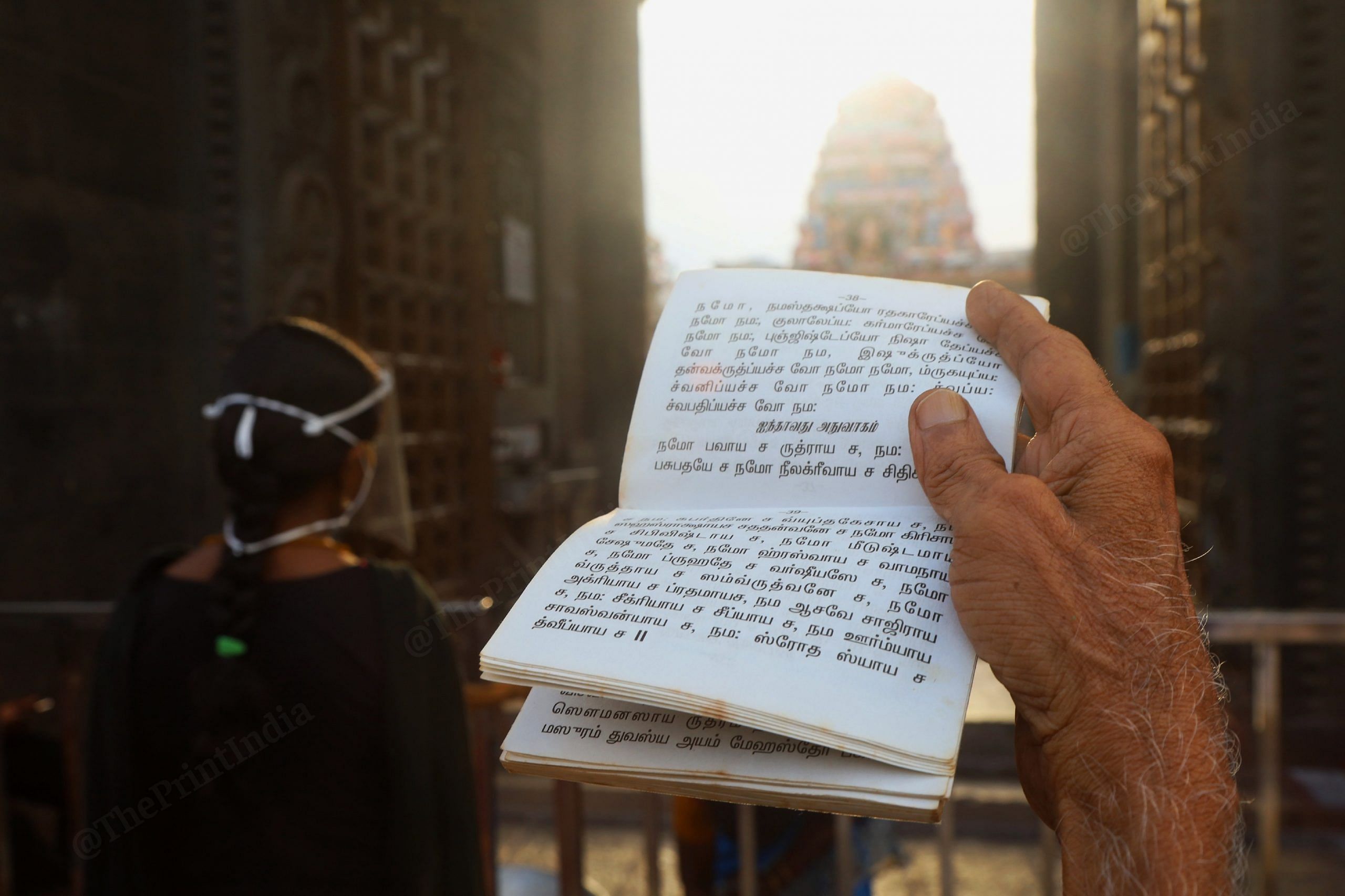 A devotee reads shlokas outside the temple. Photo: Manisha Mondal/ThePrint