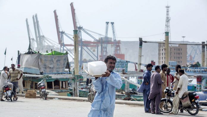 A man carries a block of ice at the harbor at Gwadar Port in Gwadar, Balochistan, Pakistan (Representational image) | Bloomberg